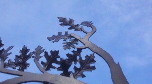 Picture of plasma cut oak tree branches and stamped steel leaves with sky as the background