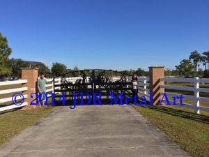 Sarasota entrance gates featuring plasma cut scene of horses standing at a fence.