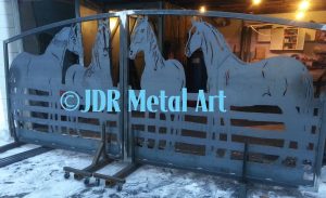Drive gate featuring metal horse silhouettes.