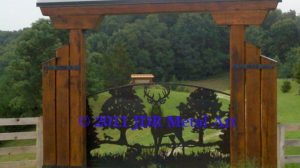 Metal art front driveway gate with silhouettes of deer fox turkey pine oak trees.