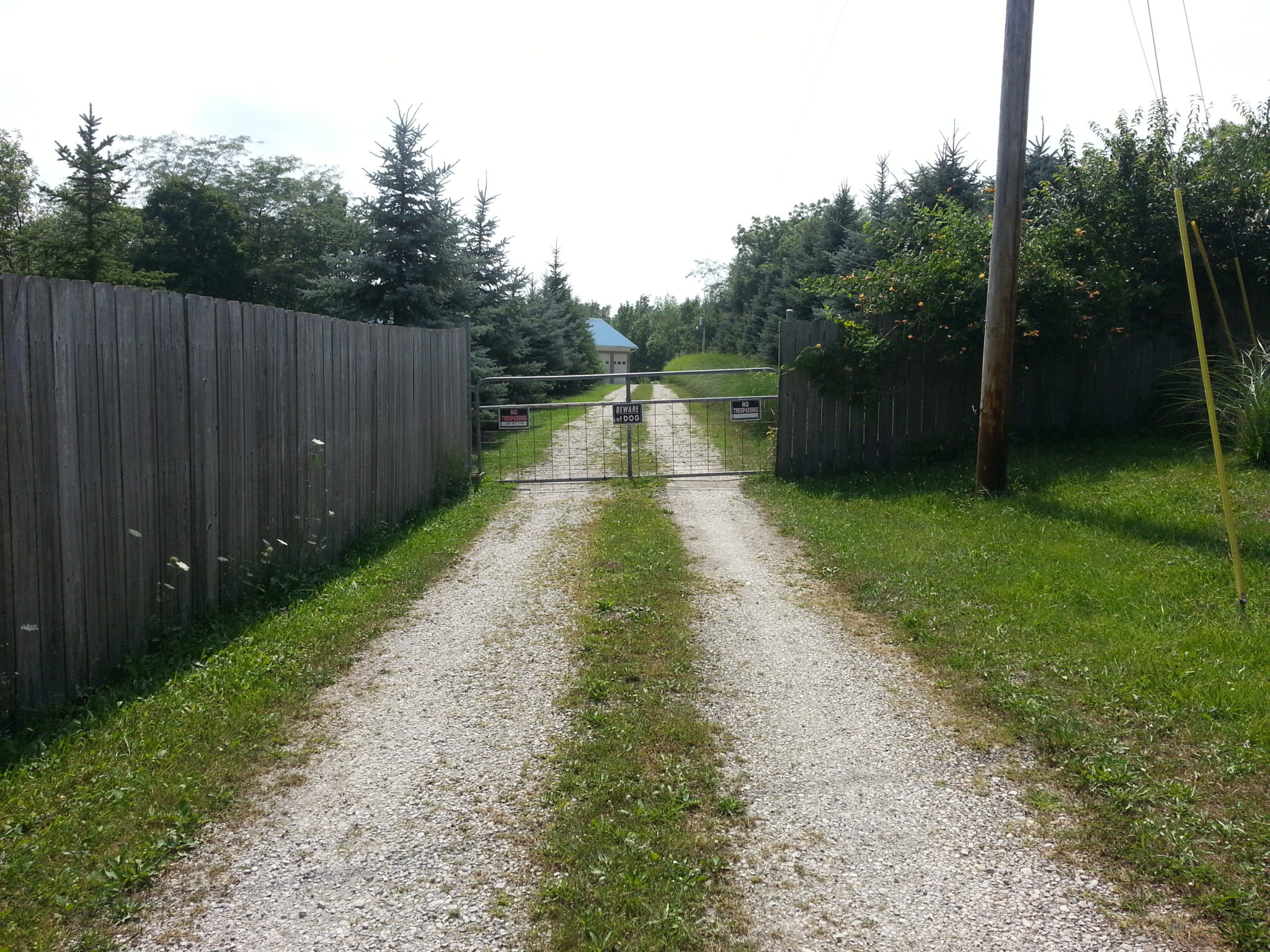 Original driveway entrance before we updated it by installing custom sliding driveway gates.