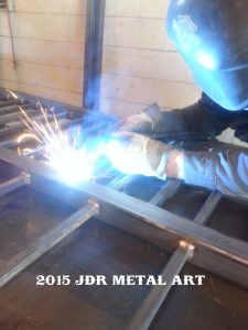 Building a driveway gate with a mig welder and steel pickets being welded to the gate frame.