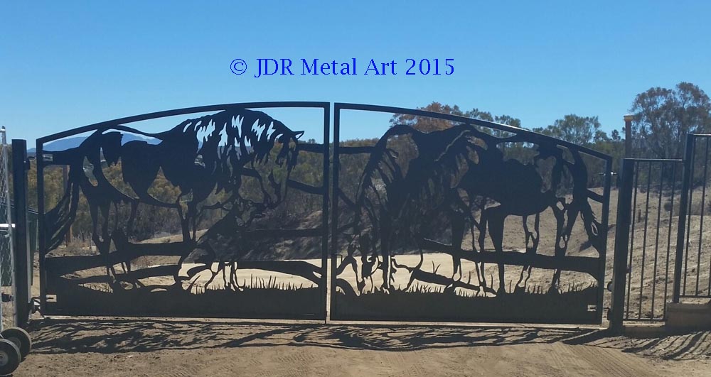 Driveway security gates with plasma cut horses and German Shephard design at California residential entrance.