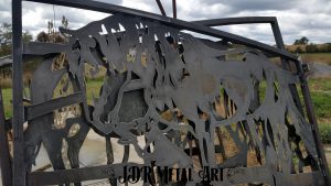 Raw steel gate with horse and german shepherd design before sandblasting.