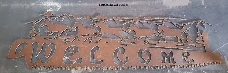 This metal sign was plasma cut with horses and mountains in the background.