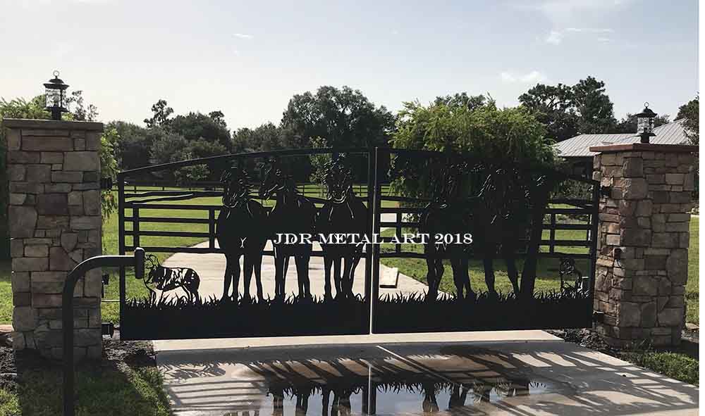 Driveway entrance with custom gated access controls. Design of horses on driveway gates.