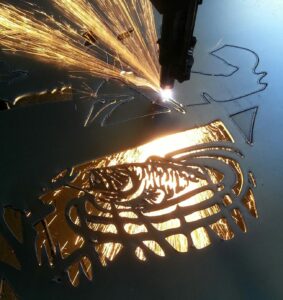 Plasma cutting a metal art bass that is jumping out of the water and chasing a dragonfly.