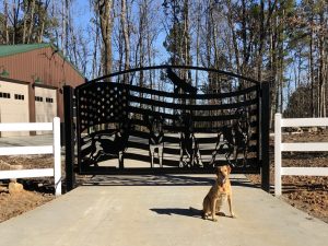 American flag themed driveway gate with dogs