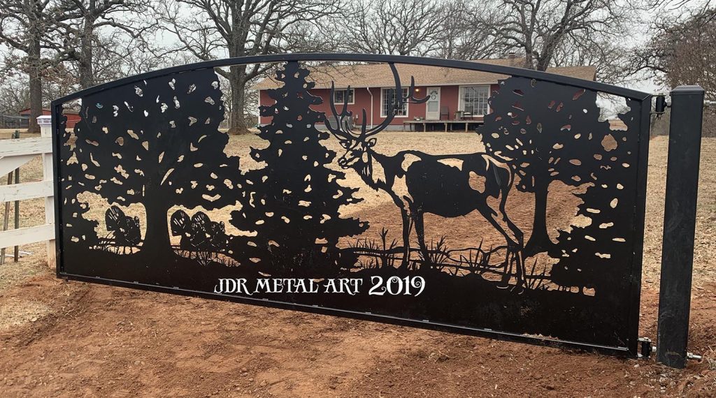 Elk and turkey design on metal farm gate in Oklahoma.