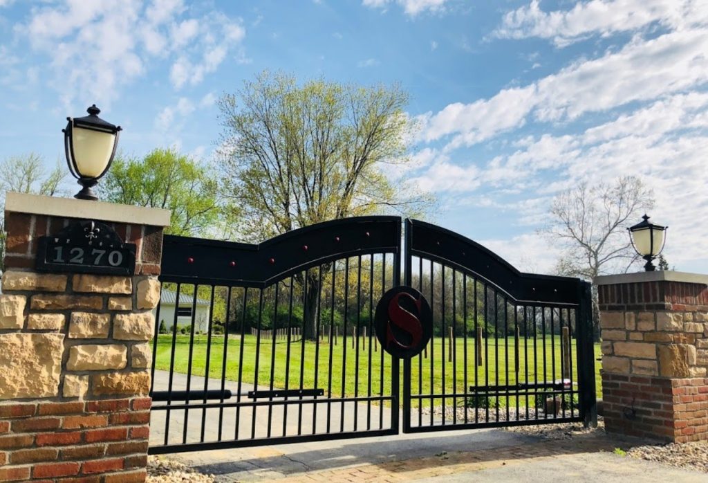 Driveway gate designed for Dublin Ohio estate featuring hammered clavos and powder coated iron details. Heavy duty 7 gauge steel fabrication by JDR Metal Art.