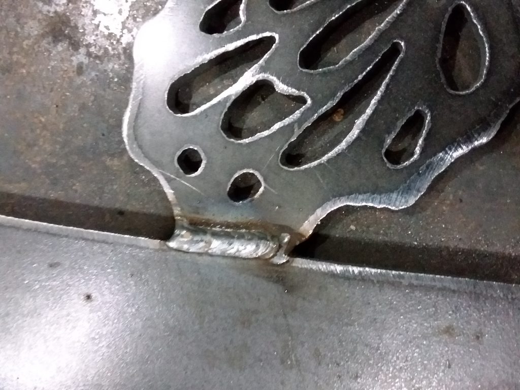 Picture of a mig weld on a driveway gate emblem.