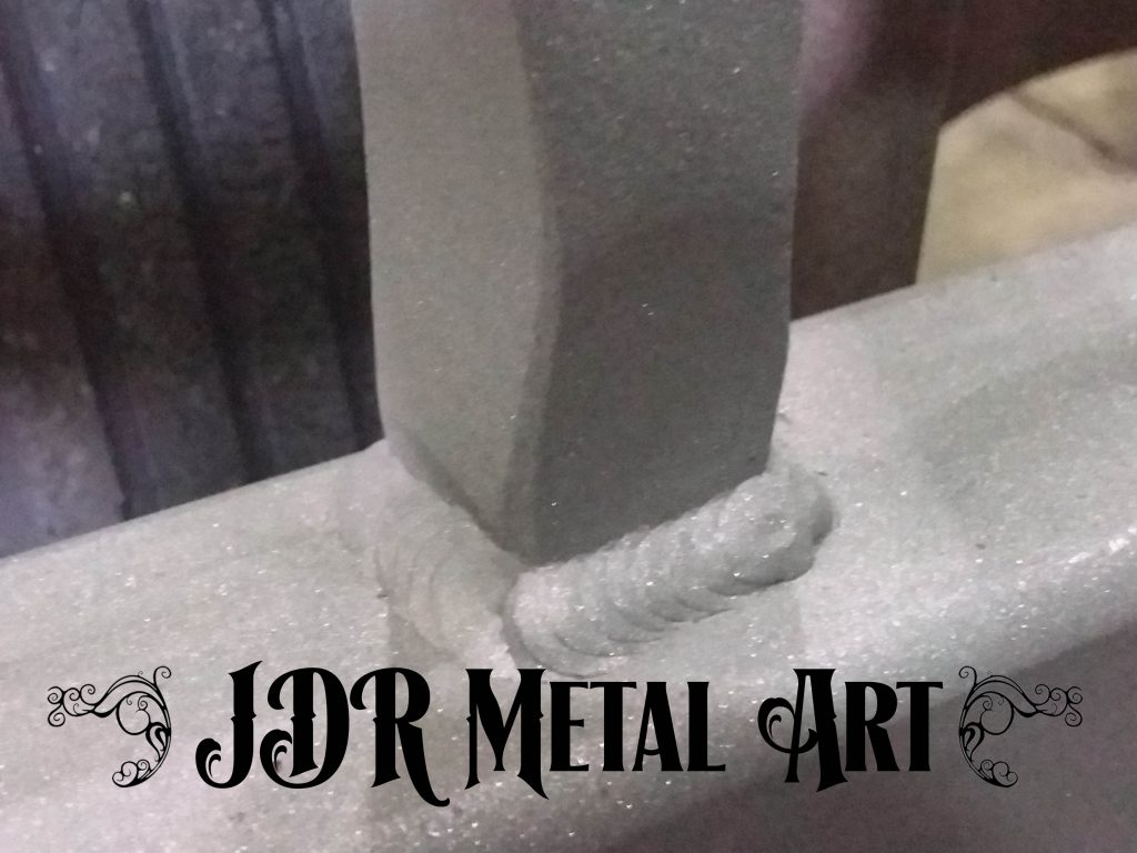 Welded metal element for ornamental driveway gate.