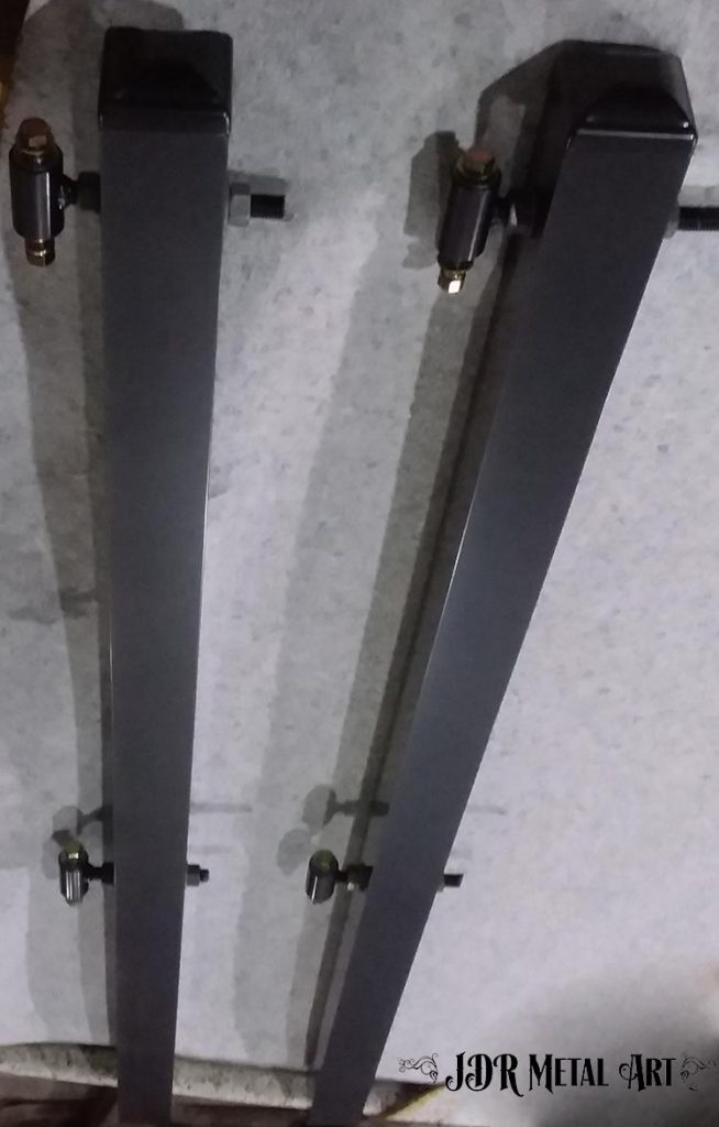 Driveway gate posts with hinges and post caps.