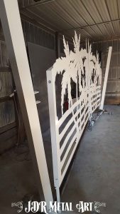 Side view of white powder coated aluminum drive gates and gate posts.