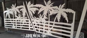 Aluminum driveway gates with palm tree design that is powder coated white.