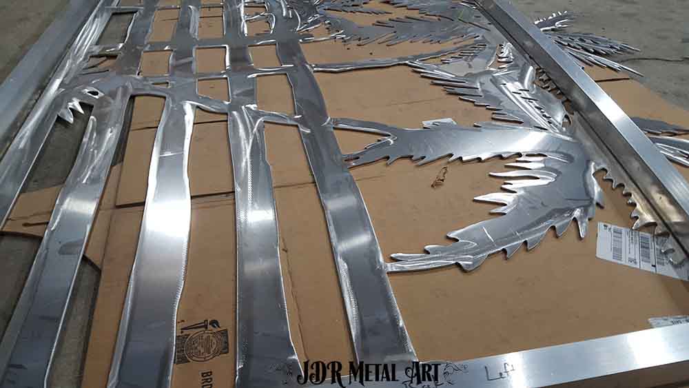 Plasma cut metal art palm trees and fence design.