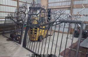 Dual swing iron gate designs with oak tree.