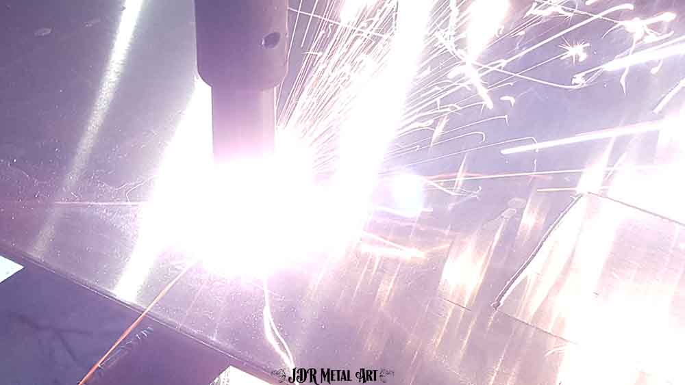 Plasma cutting sparks from aluminum sheet.
