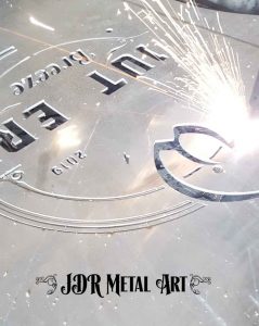 Plasma cutting gate logo from aluminium sheet metal.