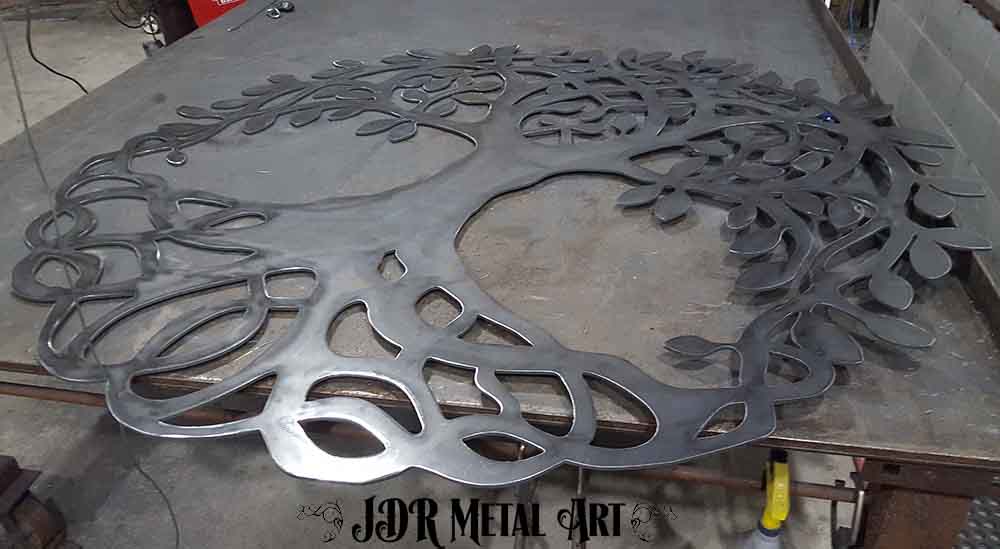 1/4" steel plate after it has been plasma cut into a tree of life iron gate design.
