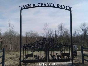 Metal art driveway gates for ranch entrance.