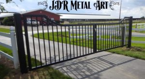 Ranch driveway gates, in front of large cattle farm barn.