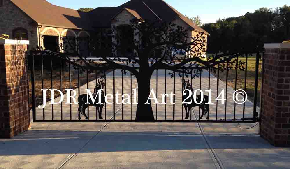 Black single swing driveway gates hanging from brick columns.