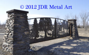 Corten steel metal driveway gate hanging from rock columns.