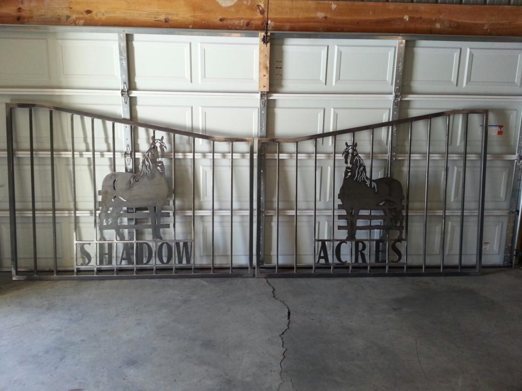 Driveway gate with design of horse for traditional concrete driveway entrance.