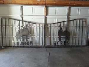 Driveway gate with design of horse for traditional concrete driveway entrance.
