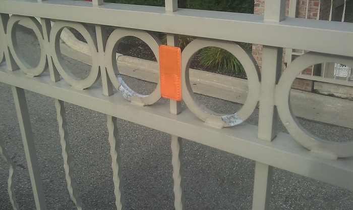 Paint peeling off of an aluminum estate gate.