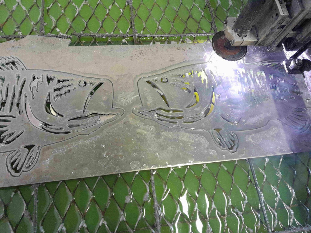 Plasma cutting aluminum bass silhouettes for metal driveway gate.