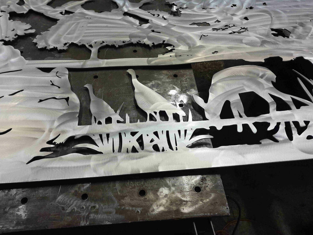 Plasma cut aluminum silhouettes featuring turkeys and deer grazing in a grassy knoll.