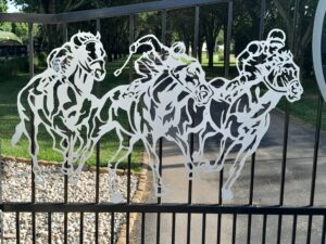 Driveway gate with horse and jockey silhouette plasma cut from aluminum.