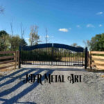 Black driveway gates securing Louisville, Kentucky property with Kentucky 4 board fence attached to the gate posts.