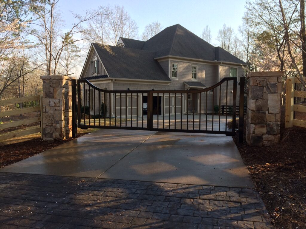 Atlanta driveway gate with curved top and pickets.