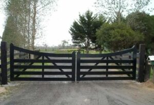 Driveway gate design with inverted arch top, built from metal such as steel or aluminum to secure driveway entry.