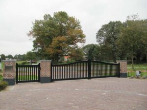 Perfect driveway gate idea with a dual swing arched top metal gate design including pickets and side panels.