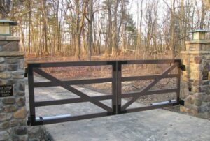 An elegant metal driveway gate design featuring steel frame and downward oriented frame supports.