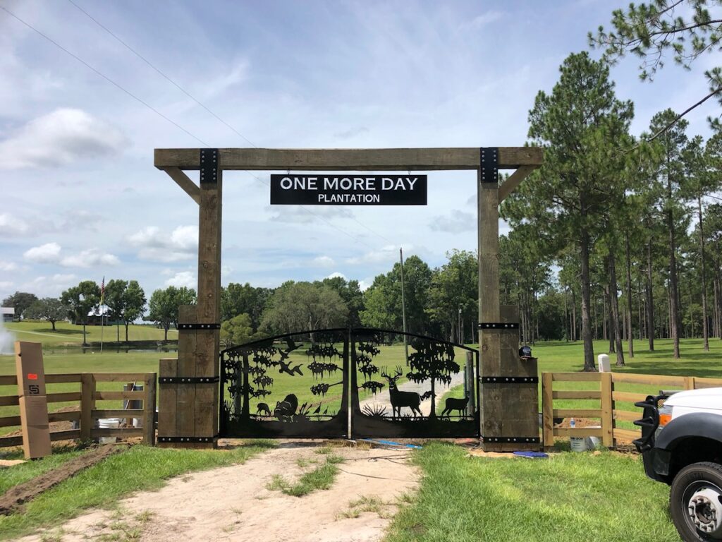 Georgia Plantation Entrance Gate Design Aluminum Custom aluminum dual swing driveway gate installed at One More Day Plantation in Southern Georgia featuring timber frame overhead beam.