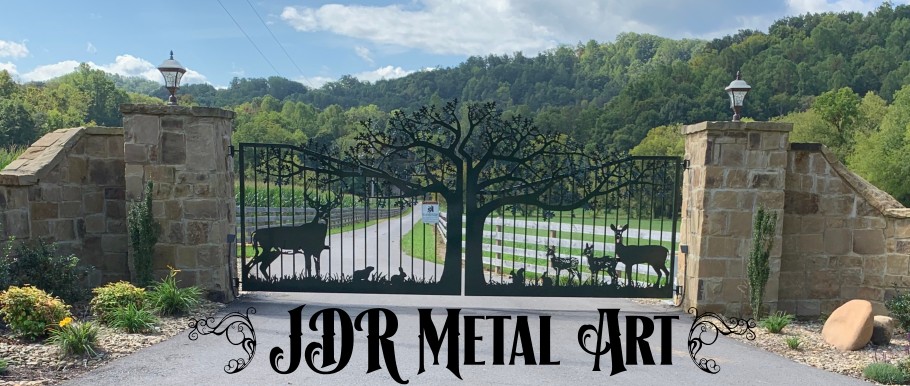 Set of driveway gates with custom metal decorative elements and ornamental designs of deer beneath an oak tree with pickets, custom hinges and an automatic gate opener system hung by JDR Metal Art.