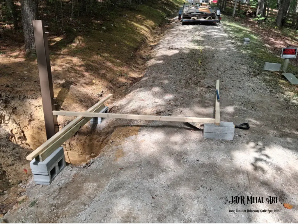 Knoxville TN Custom Driveway Gates | JDR Metal Art (Horse Theme, Steel Frame & Rough Sawn Cedar) 5 Gate post being set for custom driveway gate installation on wooded property near Knoxville, TN